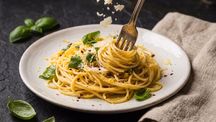 light pasta dish with lemon, basil and cherry tomatoes on a white plate